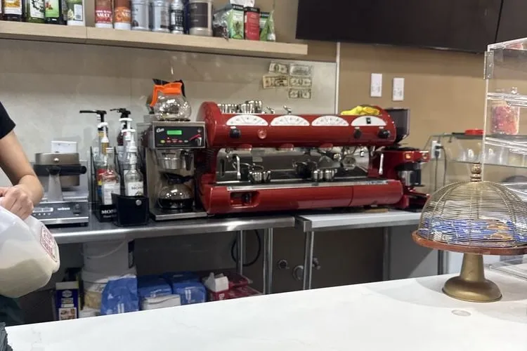 Barista working at the espresso machine behind the counter at Parfait Café