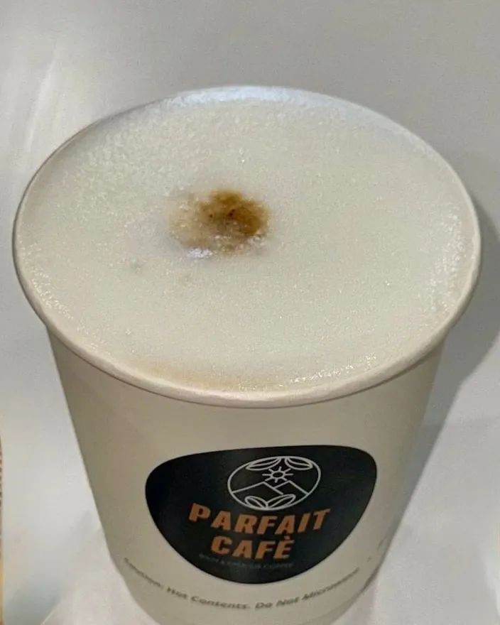 Latte in a Parfait Café cup, seen from above with a smooth microfoam surface